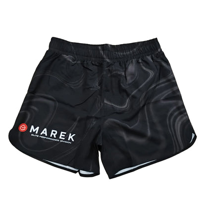 Black athletic shorts with a dark gray wavy pattern, featuring a white 'MAREK' logo and a small red smiley face on the left leg, displayed against a solid white background.